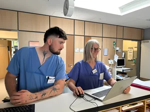 Am Stationsstützpunkt schaut Tobias Bauer der erfahrenen Stationsleitung Gabi Rieder über die Schulter - Bild: medbo KU / Kerstin Erbrich