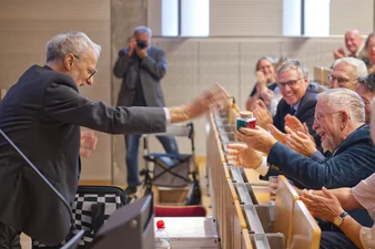 Ein symbolisches Geschenk sorgt für einige Lacher im Publikum: Prof. Reinhard Hohlfeld "zaubert" einen Rubi-Cube live in ein Glas. (c) medbo KU Johannes Müller