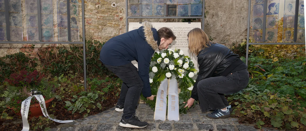 Erinnern für die Zukunft: Ausbildende des Bezirksklinikums Regensburg übernahmen die Kranzniederlegung am Denkmal im Kirchhof St. Vitus. © medbo KU / Katharina Tenberge-Holzer