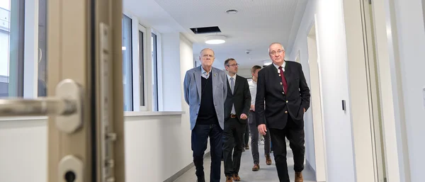 Franz Löffler (re.) und Lothar Höher (li.) beim Rundgang durch den Neubau der Kinder- und Jugendpsychiatrie in Weiden. Der künftige Chefarzt David Aue (Mitte) gab einen Ausblick darauf, wie die noch leeren Räume bald mit Leben und Versorgung gefüllt werden. (c) medbo KU – Johannes Müller