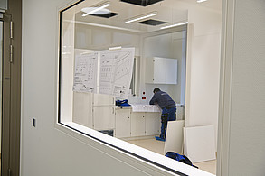 Ein Arbeiter prüft die Baupläne im künftigen Stationszimmer: Noch wird gearbeitet, doch das Klinikgebäude nimmt sichtbar Gestalt an. (c) medbo KU – Johannes Müller