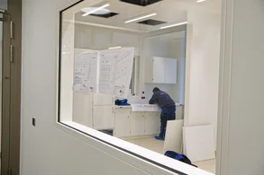 Ein Arbeiter prüft die Baupläne im künftigen Stationszimmer: Noch wird gearbeitet, doch das Klinikgebäude nimmt sichtbar Gestalt an. (c) medbo KU – Johannes Müller